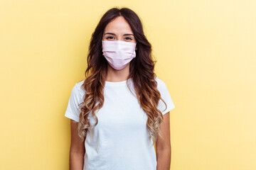 Young mixed race woman wearing a protection for virus isolated on yellow background Young mixed race woman wearing a protection for virus isolated on yellow background happy, smiling and cheerful.