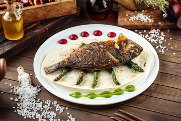 Dish of gourmet grilled dorada fish on the wooden background