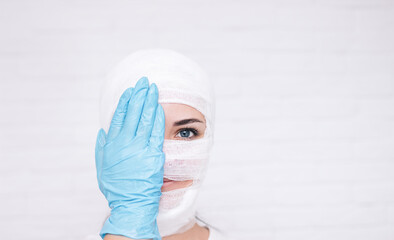 close-up of a girl's face in medical bandages after surgery on a white background.place for the test - obrazy, fototapety, plakaty