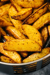 Spicy potato wedges in an air fryer basket