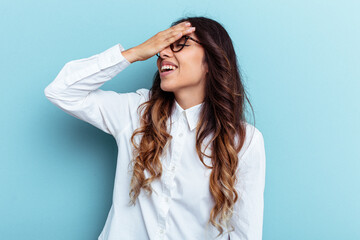 Naklejka premium Young mexican woman isolated on blue background covers eyes with hands, smiles broadly waiting for a surprise.