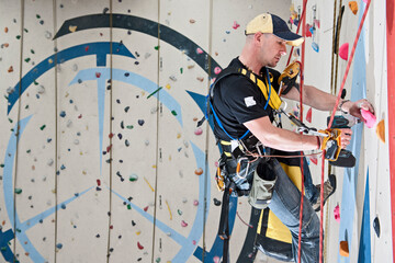 man setting climbing routes at indoor climbing centre