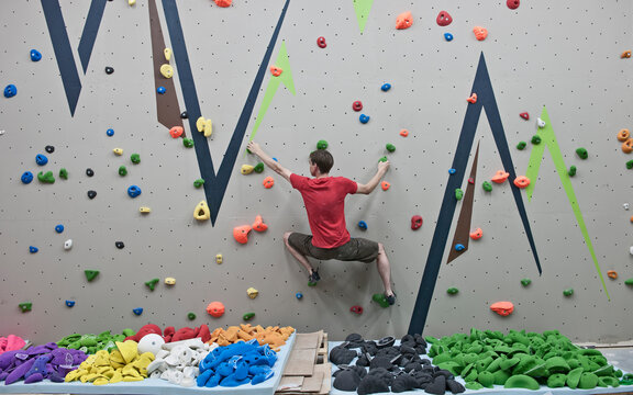 rout setter trying new bouldering problems at indoor climbing wall