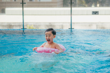 Cute kid swimming in a pool with clear water