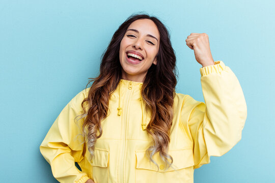 Young mexican woman isolated on blue background cheering carefree and excited. Victory concept.