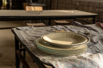 Dishes on a wooden table, in an abandoned hotel.