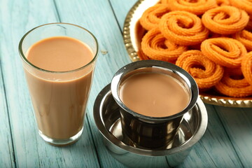 Indian milk masala tea, chai served with chakli snack - evening tea time backgrounds.