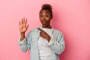 Young african american woman isolated on pink background smiling cheerful showing number five with fingers.