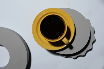 yellow coffee cup with gray geometric figures on wood