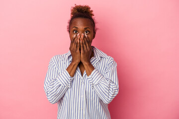 Young african american woman isolated on pink background shocked, covering mouth with hands, anxious to discover something new.