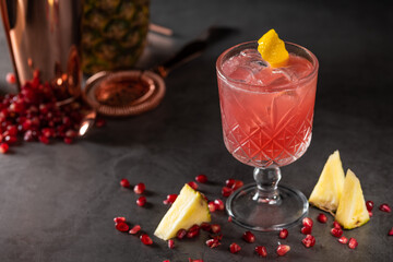 refreshing and light pomegranate and pineapple summer cocktail with ice cubes
