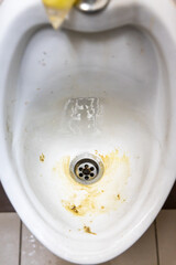 Close-up of dirty and smelly urinal bowl with limescale stain deposits