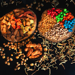 A varied beer snack. crackers, nuts, smoked cheese, salted peanuts and colored glaze. top view on a dark background.
