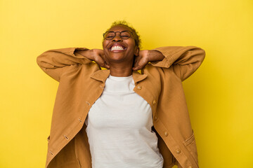 Young african american woman isolated on yellow background feeling confident, with hands behind the head.