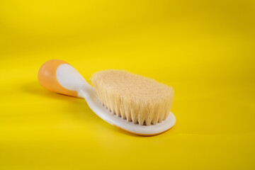 Fototapeta na wymiar Comb baby's hair on a yellow background