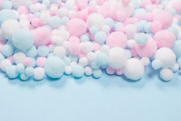 White, pink and blue soft pompons as a background.