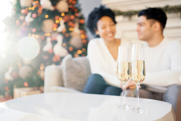 A young happy couple are preparing for Christmas. Celebrate the holiday with champagne in glasses. New Year's weekend on the eve.
