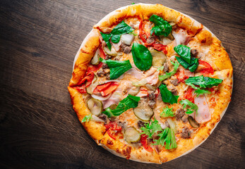Pizza with Mozzarella cheese, Bolognese sauce, minced meat, bacon, tomato and vegetables. Italian pizza on wooden background.