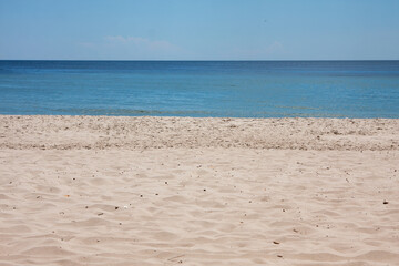 Fototapeta na wymiar Tropical beach view. Calm and relaxing empty beach scene, blue sky and white sand.