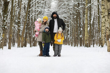 Fototapeta na wymiar Happy family playing and laughing in winter outdoors in the snow. City park winter day.