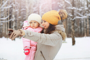 Obraz premium Happy family playing and laughing in winter outdoors in the snow. City park winter day.