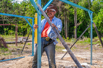 Obraz premium Gardeners use cordless screwdriver and spirit level while building nursery structures from c channel steel in the garden.