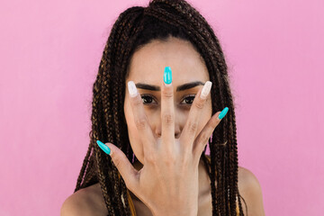 Bohemian girl looking at camera while showing her hand with long acrylic nails - Main focus on hand