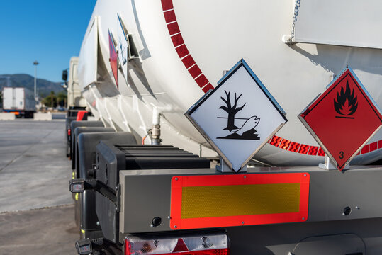 Tank truck with dangerous goods, with labels of flammable and pollutant of the environment.