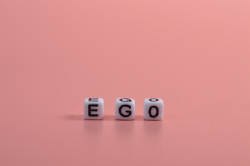 Alphabet beads with text EGO isolated on pink background