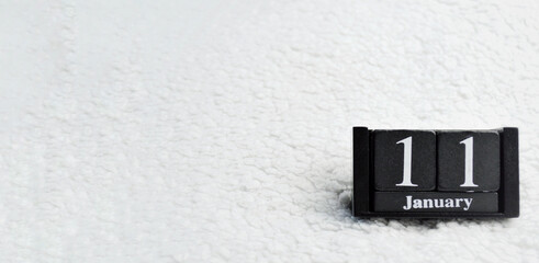 Wooden calendar from blocks on white background with copy space. 11th of January