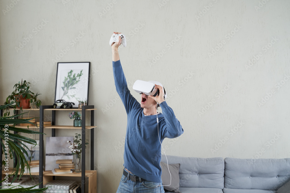 Wall mural man with virtual reality headset is playing game.