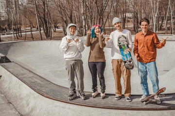 Two rollers and two skaters are looking forward to the return of warmth and the opportunity to ride on a skatepark in their city spring / autumn