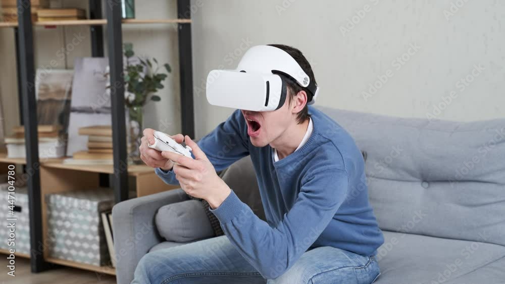 Wall mural man is playing game with virtual reality headset and joystick