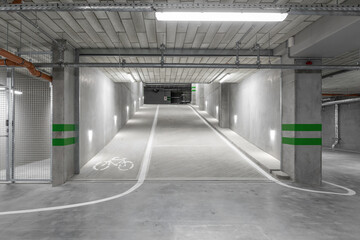 Empty public underground parking lot or garage interior with concrete stripe painted columns and...