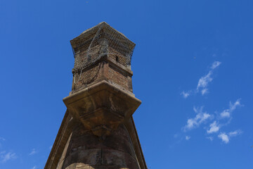 Fototapeta na wymiar Old castle turret, red brick watch-tower in bright blue sky