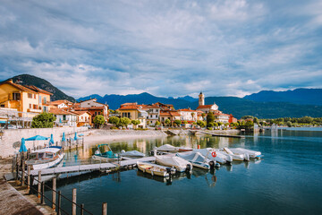 Fototapeta na wymiar Feriolo, Verbania / Italy - June 2021: Feriolo village on Lake Maggiore with cloudy sky with small boats moored in the foreground