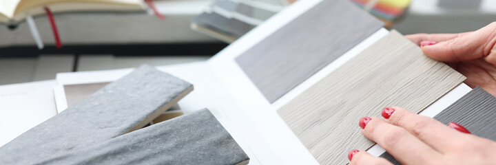 Woman choosing color of laminate board in design studio closeup