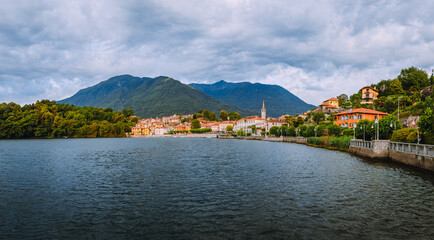 Fototapeta na wymiar Mergozzo, Verbania / Italy - June 2021: View of the village of Mergozzo on the homonymous lake with cloudy sky