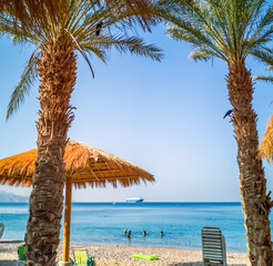 Sandy beach with sunshades and safe swimming area of the Red Sea in Eilat – famous tourist resort...