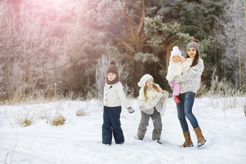 Obraz premium Happy family playing and laughing in winter outdoors in the snow. City park winter day.