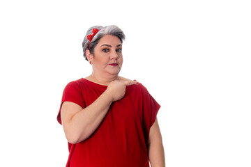 young lady wearing red outfit on white background pointing to the side with serious expression.