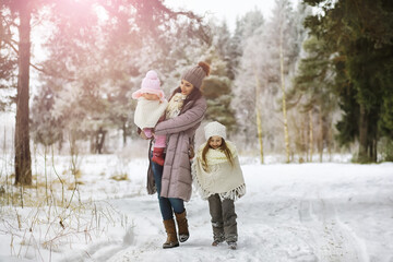 Happy family playing and laughing in winter outdoors in the snow. City park winter day.