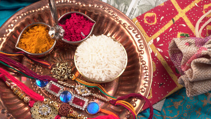 Indian festival: Raksha Bandhan background with an elegant Rakhi, Rice Grains and Kumkum. A traditional Indian wrist band which is a symbol of love between Brothers and Sisters.
