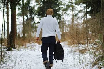 Outdoor portrait of handsome man in coat and scurf. Bearded man in the winter woods.