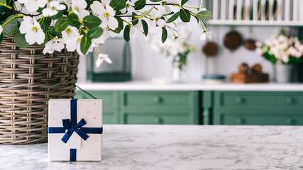 Gift box with blue ribbon on kitchen table