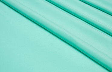 Smooth elegant mint color tissue abstract background. Textile background. Cloth wallpaper. Graphics...