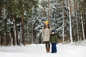 Happy family playing and laughing in winter outdoors in the snow. City park winter day.