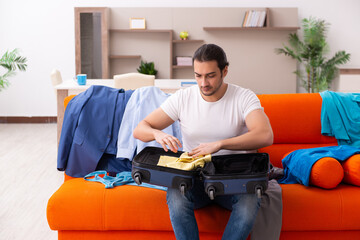 Young man student preparing for trip at home