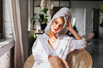 Beautiful female portrait. Woman wearing red lipstick and turban towel on head while relaxing at...