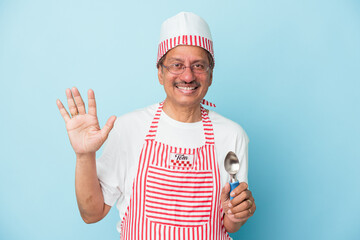 Senior indian ice cream man holding a scoop isolated on blue background smiling cheerful showing number five with fingers.